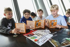 Angelos, Neo, Benni und Benjamin (v.l.) gehören zu den ersten begeisterten Lesern des neuen Bandes von Rheinhold und Rheinhilde "Mein Körper - Meine Stadt". Foto: Landeshauptstadt Düsseldorf/Melanie Zanin