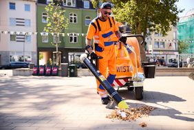 Müllwerker mit handgeführtem Müllsauger bei der Arbeit
