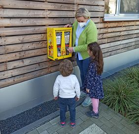 Babette de Fries, Leiterin des Familienzentrums Angermund, mit (v.l.) Emilius und Leona am neuen Bienenfutterautomaten, © Landeshauptstadt Düsseldorf