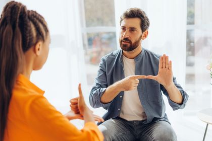 Frau und Mann unterhalten sich in Gebärdensprache, Foto: iStock, Mariia Vitkovska