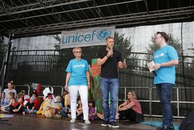 Fortuna-Stürmer und "Kids United"-Botschafter Rouwen Hennings (Mitte) mit Brigitte Herzmann auf der UNICEF-Bühne