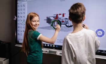 Zwei Lernende arbeiten gemeinsam an einem interaktiven Smartboard