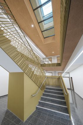 Eine offene Treppe im Innern ermöglicht direkten Zugang zum Lernzentrum und der Berufsberatung. Die Geschosse oberhalb verfügen über einen Glasdeckel, sodass alle Geschosse mit Tageslicht versorgt werden. Foto: Gstettenbauer