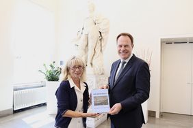 Oberbürgermeister Dr. Stephan Keller übergab die Festschrift "Der Rhein bewegt" an Dr. Annette Fimpeler, die fast vier Jahrzehnte das SchifffahrtMuseum prägte. Foto: Landeshauptstadt Düsseldorf/Ingo Lammert