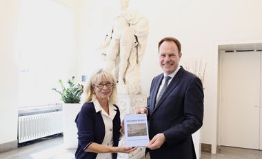 Oberbürgermeister Dr. Stephan Keller übergab die Festschrift "Der Rhein bewegt" an Dr. Annette Fimpeler, die fast vier Jahrzehnte das SchifffahrtMuseum prägte. Foto: Landeshauptstadt Düsseldorf/Ingo Lammert
