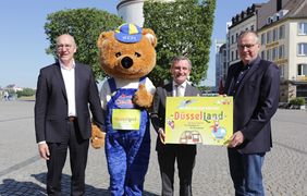 Stellten das Konzept für den temporären Freizeitpark "Düsselland" vor (v.l.): Clemens Hauser, Messe Düsseldorf, das Düsselland-Maskottchen, OB Thomas Geisel und Schausteller Oscar Bruch. Foto: Ingo Lammert