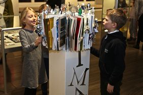 Zwei Kinder schauen sich eine Projektarbeit in der Ausstellung 'Kinder haben Rechte' im Rathaus an