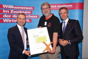 Den Preis in der Kategorie Handwerk erhielt Dirk Schmidt, Atelier für Holzbearbeitung (Mitte), aus der Hand von Oberbürgermeister Thomas Geisel (links) und Handwerkskammerpräsident Andreas Ehlert. Foto: David Young