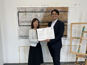 Yukiko Itakura, Leiterin des Büros für Sport und Kultur der Präfektur Chiba, und Rajiv Strauß, stellvertretender Leiter des Kulturamtes, präsentieren die Vereinbarung über den Start des Künstleraustausches © Landeshauptstadt Düsseldorf/Kulturamt 