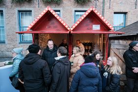 Oberbürgermeister Dr. Stephan Keller im Gespräch mit Besucherinnen und Besuchern der neuen Weihnachtshütte für das Düsseldorfer Ehrenamt auf dem Weihnachtsmarkt vor dem Rathaus.
