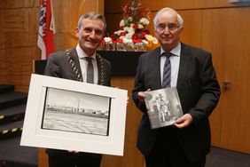 OB Thomas Geisel (links) und Professor Dr. Peter Richter mit Präsenten der Bernd-und-Hilla-Becher-Preisträgerin Evelyn Richter