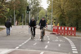 Foto von OB Dr. Keller und Mobilitätsdezernent Jochen Kral, die mit dem FAhrrad auf dem neuen Zweirichtungsradweg an der Hofgartenrampe fahren.