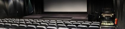 Zuschauerraum des Kinos Black Box mit Blick auf die Leinwand und Kinoorgel.