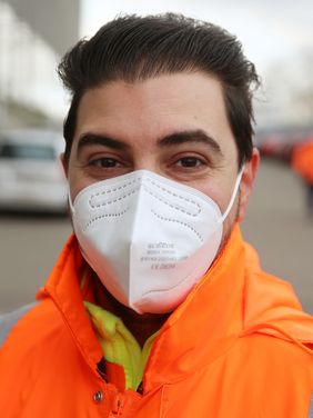 Taner Yildirim, Mitarbeiter des Klüh Wheelchair Services, hilft mobilitätseingeschränkten Besuchern in das Impfzentrum. Foto: David Young