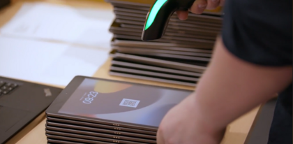 Mehrere gestapelte Tablets werden mit einem Handscanner erfasst 