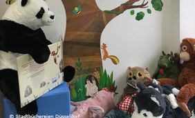 Foto von Kuscheltieren mit Bilderbuch