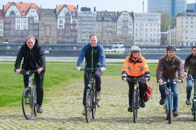 Foto von Oberbürgermeister Stephan Keller, Mobilitäts- und Umweltdezernent Jochen Kral und weiteren städtischen Mitarbeitern auf Fahrrädern an den Rheinwiesen.