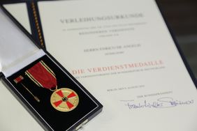 Die Verdienstmedaille des Verdienstordens der Bundesrepublik Deutschland sowie die dazugehörige Verleihungsurkunde. Foto: Ingo Lammert