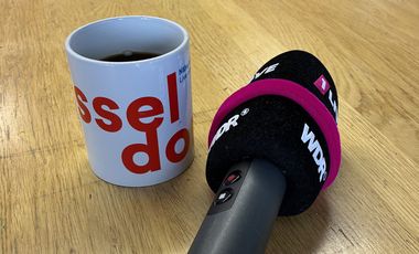 WDR-Mikrofon neben Kaffeetasse mit Düsseldorf-Branding © Gesundheitsamt Düsseldorf