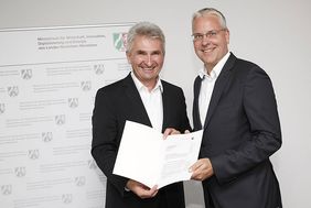 Prof. Dr. Andreas Pinkwart (links), NRW-Minister für Wirtschaft, Innovation, Digitalisierung und Energie mit Peter Adelskamp, Digitalisierungsbeauftragter der Landeshauptstadt Düsseldorf, bei der Übergabe des Förderbescheids, Foto: MWIDE NRW/F. Wiedem