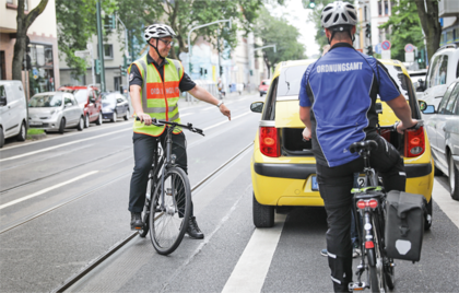 Foto von einem Falschparker auf einem Radweg, der von Mitarbeitern der Fahrradstaffel des Ordnungsamtes erfasst wird.