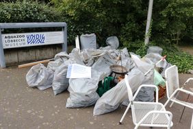 Ein großer Haufen gefüllter Müllsäcke vor einem Schild mit der Aufschrift "Aquazoo Löbbecke Museum"