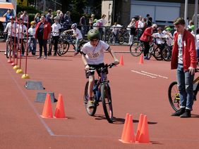 Ein Junge fährt mit einem Fahrrad durch einen Parcours