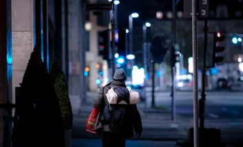 Ein obdachloser Mensch geht eine Straße hinunter