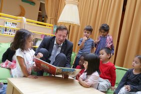 Stadtdirektor Burkhard Hintzsche zeigt den Kindern im Familienzentrum auf dem Volkardeyer Weg ein Bilderbuch. Foto: Ingo Lammert